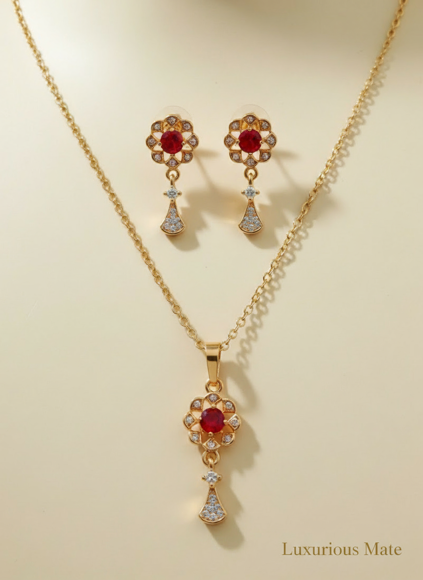 Gold jewelry set with red gemstones on a beige background