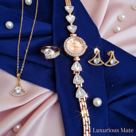 Rose gold jewelry set with necklace, earrings, and ring on a blue and pink fabric background