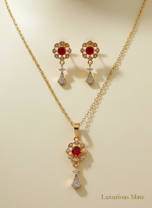 Gold jewelry set with red gemstones on a beige background