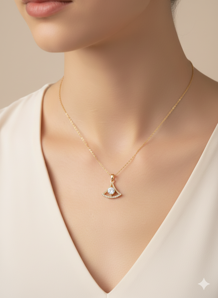 Gold necklace with a pendant worn by a person against a neutral background