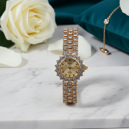 Gold watch with diamond accents on a marble surface with white roses.